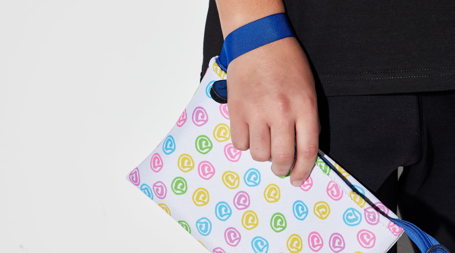 Dettaglio pochette Sassolini con pattern del marchio, fotografia reale dello shooting
